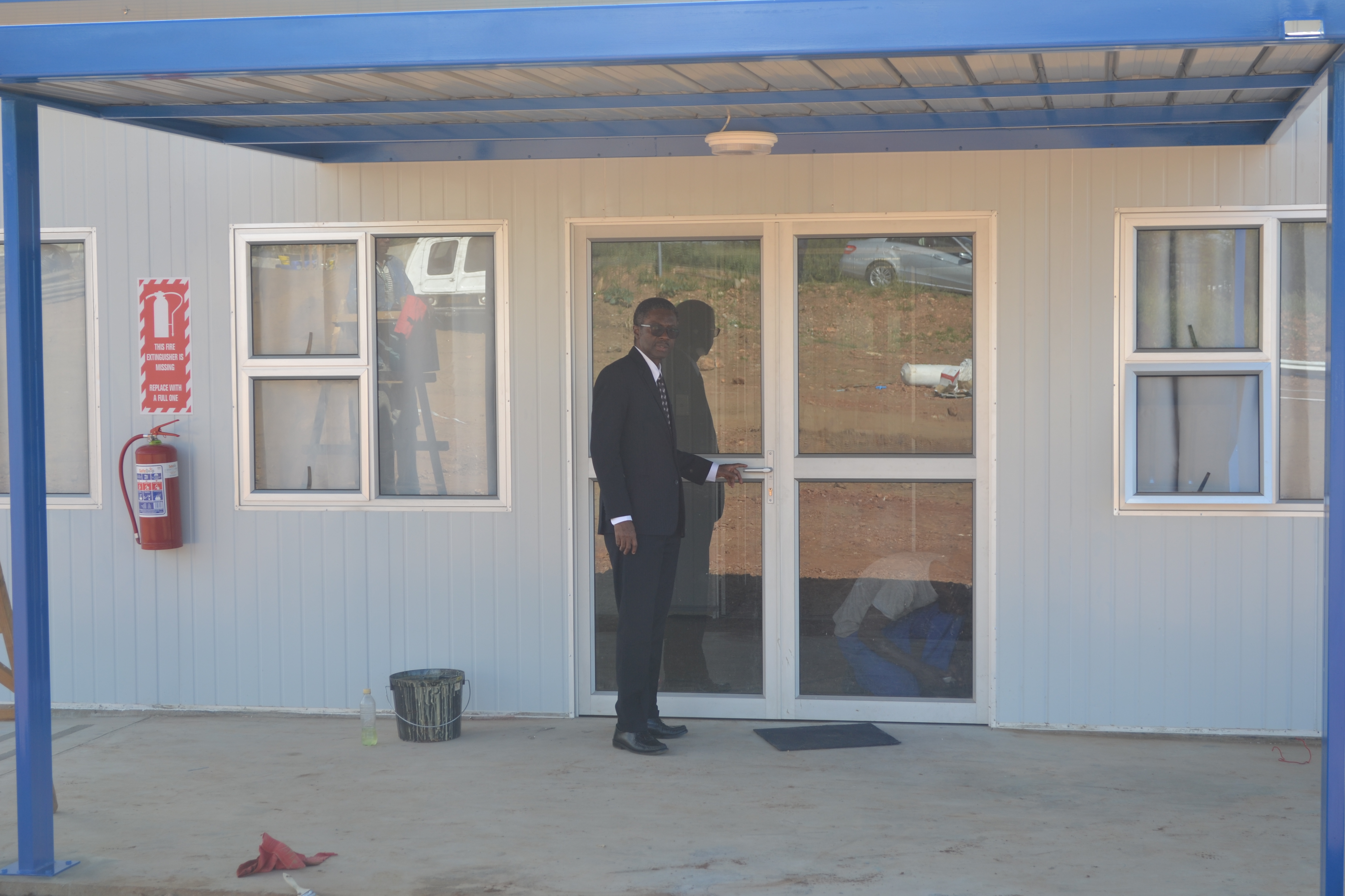WHO Representative, Dr Charles Sagoe-Moses in front of the nearly completed isolation facility. 