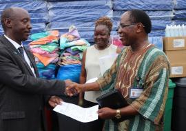 Dr Alex Gasasira handing over a consignment of assorted items for E.S Grant Hospital to Dr Francis Kateh, Deputy Minister of Health/CMO. Looking on is Mrs. Cooper, the Hospital administrator