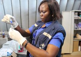 WHO South Sudan Laboratory Scientist, Jane Pita, conducts a rapid test on a specimen during a cholera investigation
