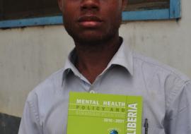 A mental health worker displaying a copy of the Mental Health Policy and Strategic Plan
