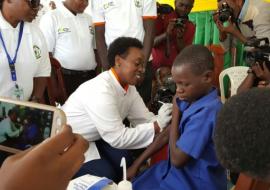 The Minister of Health, Dr Diane Gashumba vaccinating a pupil on HPV