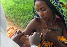 Aisha receiving oral polio vaccine at Shanga