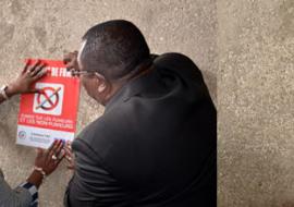 01 La Ministre ivoirienne de la sante, Dr Raymonde Goudou Coffie, aidee par le Vice Gouverneur du district d Abidjan, a affiche les 1er panneaux d interdiction de fumer sur les murs de l hotel du district