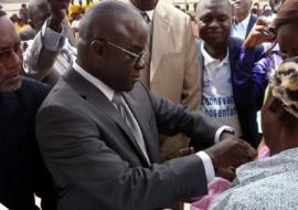 Le Ministre de la santé vaccinant un enfant contre la polio en compagnie du Représentant de l’OMS au Congo en costume clair