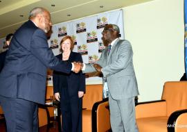 Prime Minister of Uganda Dr. Ruhakana Ruganda (left) greets WHO’s Director of Program Management- Dr. Joseph Kabore (left) as Director of the U.S. Centers for Disease Control and Prevention, Dr. Brenda Fitzgerald (inset) looks on