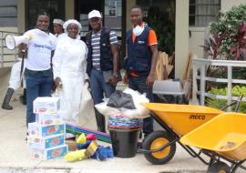 Mrs. Mama Koffa, Acting Deputy Director  JFK Medical Center, receives donation  of cleaning materials from WHO team 	