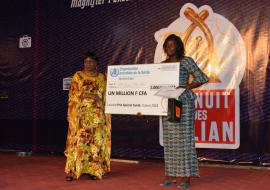 Remise du chèque et de l’attestation à la lauréate (à droite) par le Représentant  Résident de l’OMS au Burkina Faso (à gauche) à la nuit des Galian