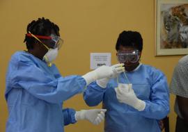Health workers practice proper donning of protective gear during the training on vaccination 