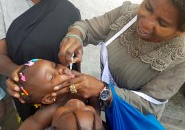 Une vaccinatrice donnant le vaccin oral polio bivalent à un enfant - dans la zone de santé de Kasa-vubu, à Kinshasa. OMS/Eugene Kabambi