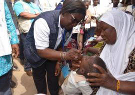 Dr Alimata J. DIARRA-NAMA, Représentant de l’OMS au Burkina Faso, administre des gouttes de vaccin à un enfant