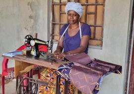 Safiatu using her sewing skills and the machine provided to her by the Mental Health Coalition of Sierra Leone to generate income