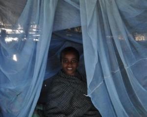 Boy sits under insecticide-treated bed net in Wonchit kebele, Dera Woreda, Amhara Region.