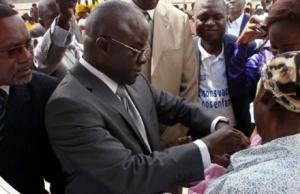 Le Ministre de la santé vaccinant un enfant contre la polio en compagnie du Représentant de l’OMS au Congo en costume clair