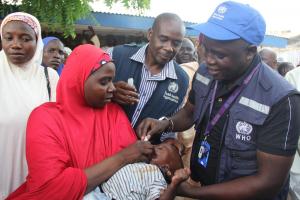 WHE Emergency Manager, Dr. Collins Owili vaccinates a child against cholera during the flagoff ceremong of the OCV campaign in Borno state. Credits: WHO CE.Onuekwe