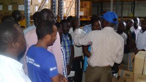 WHO Logistics Officer showing various emergency kits at the WHO central warehouse