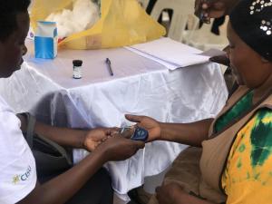 Health worker tests a community member for blood pressure during the commemoration