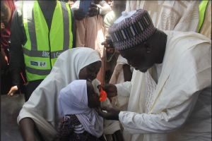 Emir of Bade, Alhaji Abubakar Umar Suleiman administers Malaria drug to an eligible child at a flag-off ceremony.