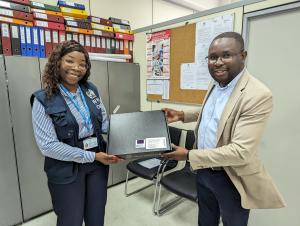 Monica from WHO presents Dr. Duarte of GEPE with a laptop, a contribution to a larger initiative aimed at improving health information