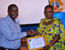 Dr Bernice Dahn, Minister of Health giving an award to the County Health Officer, Gbarpolu County