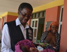 Dr Sagoe-Moses holding the newborn as the mother looks on