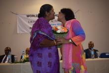 Dr (Mrs) M. Timol, Director General Health Services, receiving a bouquet from a lady 