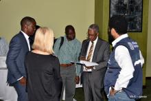 WHO Uganda Representative Dr Yonas (black suit) discusses with WHO colleagues during a break at the meeting 