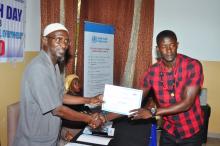 Mr. Jimbara presenting certificate to a radio presenter