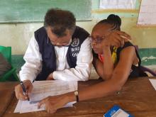 Le Dr Tedros et le Dr Moeti vérifiant le nombre de contacts fournis par l'équipe cadre de la zone de santé de Bikoro lors de la réunion locale de coordination à Bikoro. OMS/Eugene Kabambi