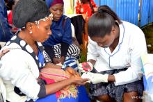A health worker takes blood pressure readings off a lady at the commemoration 