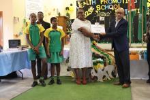 Dr Sirak Hailu, WHO Public Officer handing over a certificate to one of the Gold Health Promoting Schools 