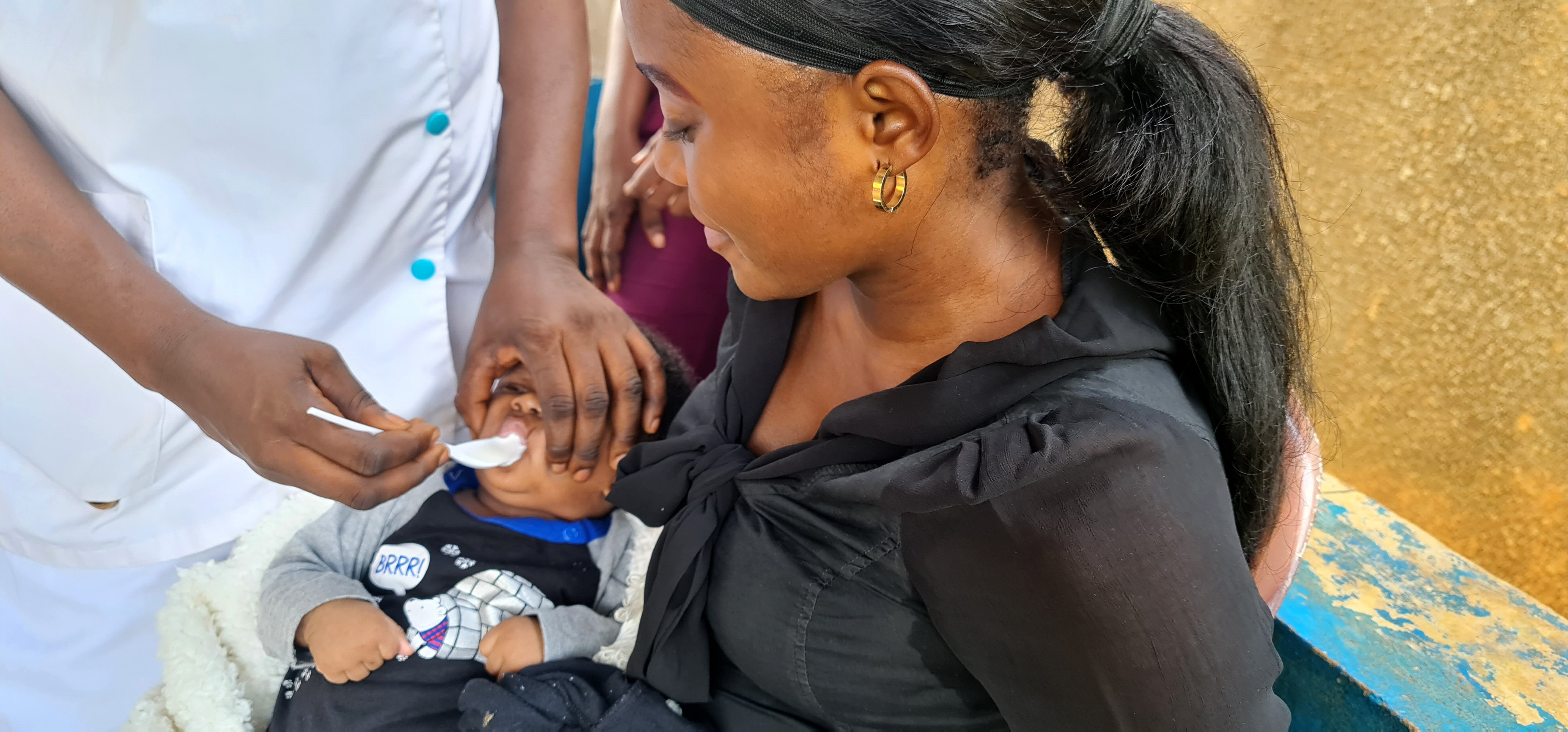 Fastina, un bébé de 10 semaines, est porté par sa maman Mantweli, pour recevoir sa première dose de la SP, administrée par l’infirmière Matondo, au centre de santé d’Etat de Loma, Mbanza-Ngungu, province du Kongo Central. OMS/Eugene Kabambi