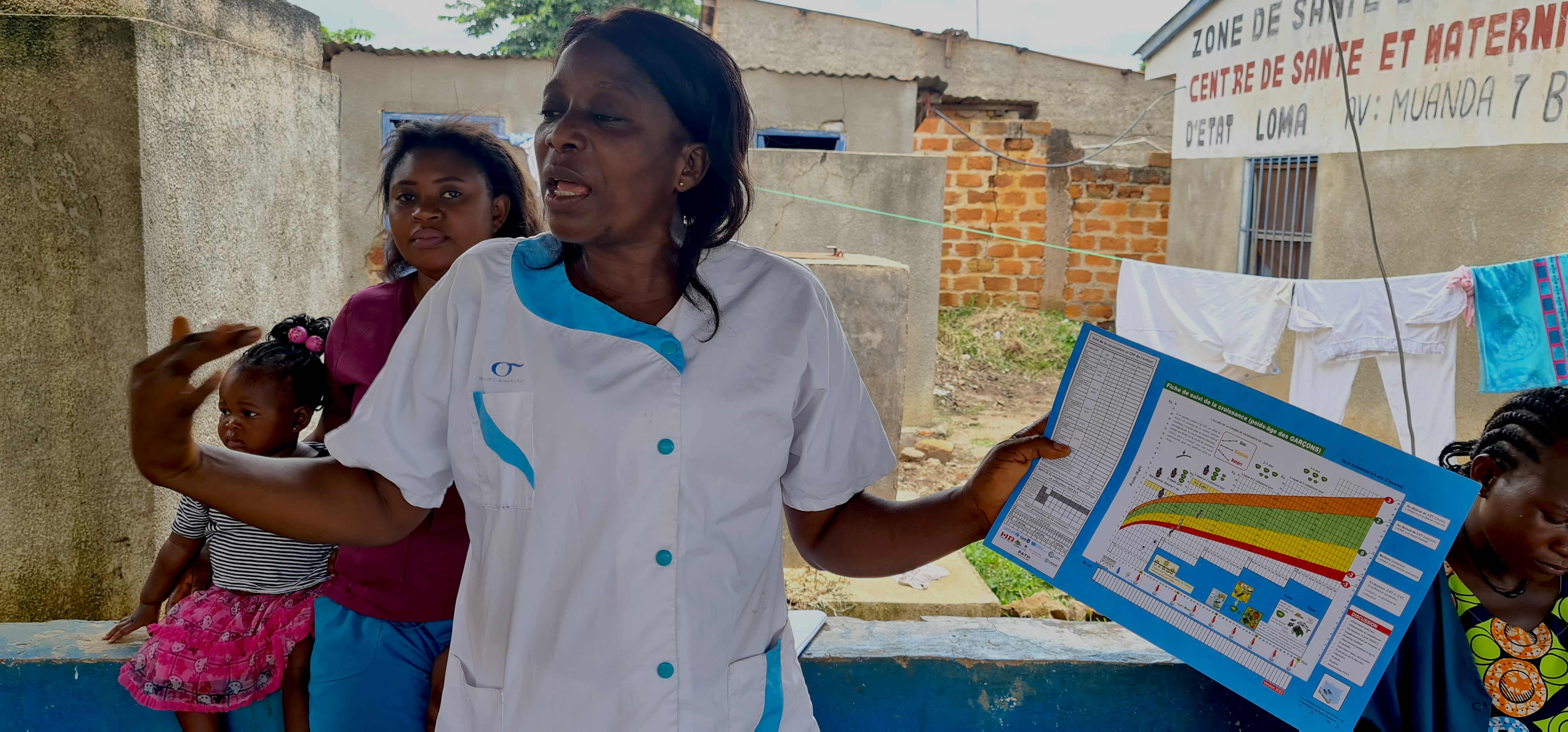 Matondo Lutekayindulanga, infirmière titulaire du centre de santé d’Etat de Loma, expliquant l’importance de la chimioprévention du paludisme pérenne aux jeunes mamans venues avec leurs bébés pour la consultation préscolaire. OMS/Eugene Kabambi.  