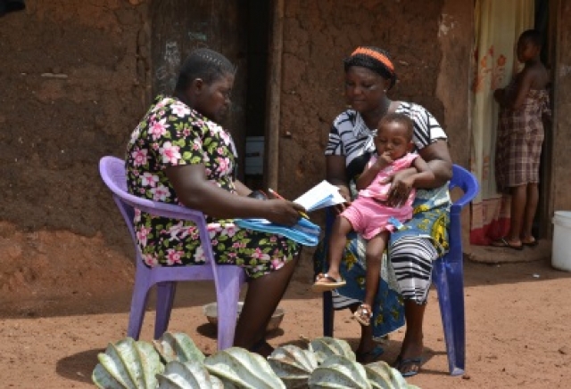 A community resource person assessing a sick child in Abia