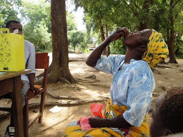 A woman taking a swig of the Oral Cholera Vaccine in Nsanje