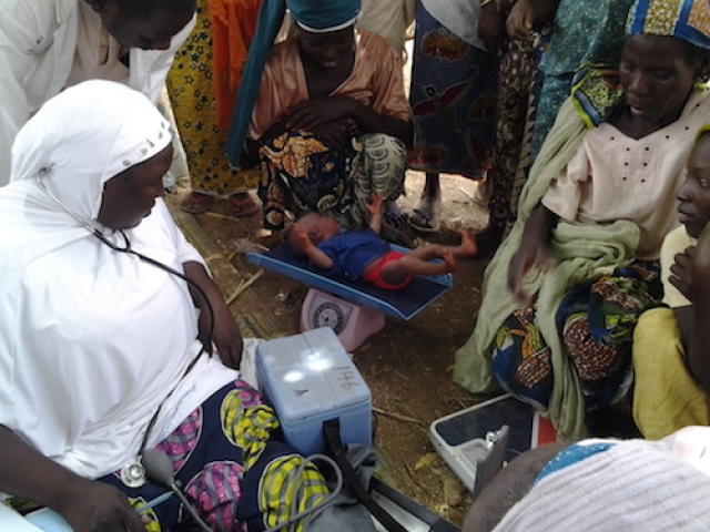 18-day old baby weighed before receiving vaccines