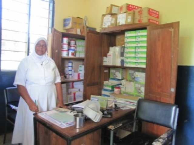A nurse at Gwata Dispensary displaying the stock of medicines and supplies.