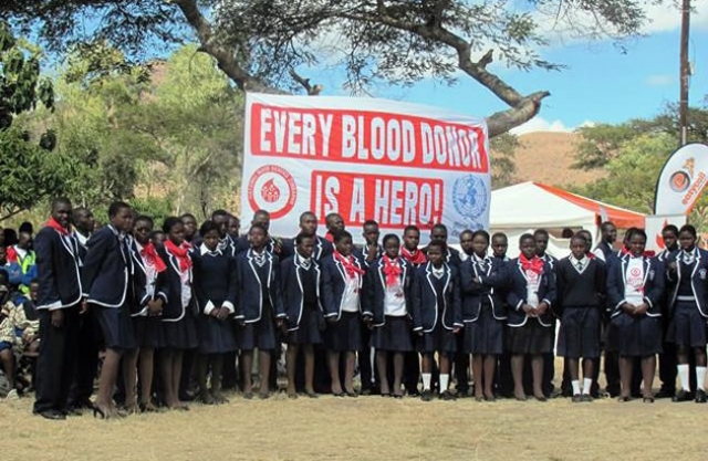Some of the blood donors in front of the banner