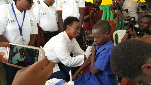 The Minister of Health, Dr Diane Gashumba vaccinating a pupil on HPV