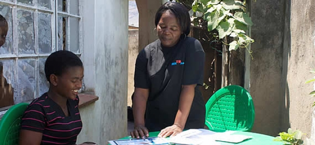 A health worker explains the process of HIV self-testing to a young woman.