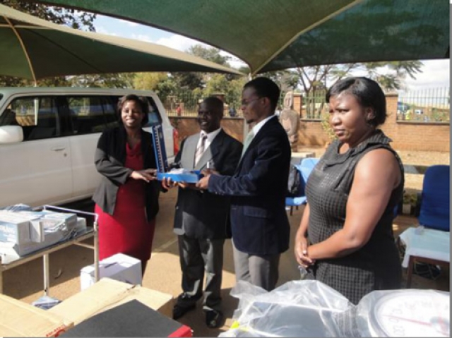 Dr Beatrice Mwagomba handingover a blood pressure machine to the Dr Nkambule, DHO Kasungu standing second left