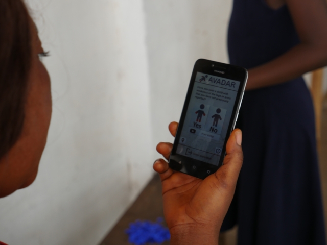 A community member putting the new technology into use to report suspected AFP cases in her locality