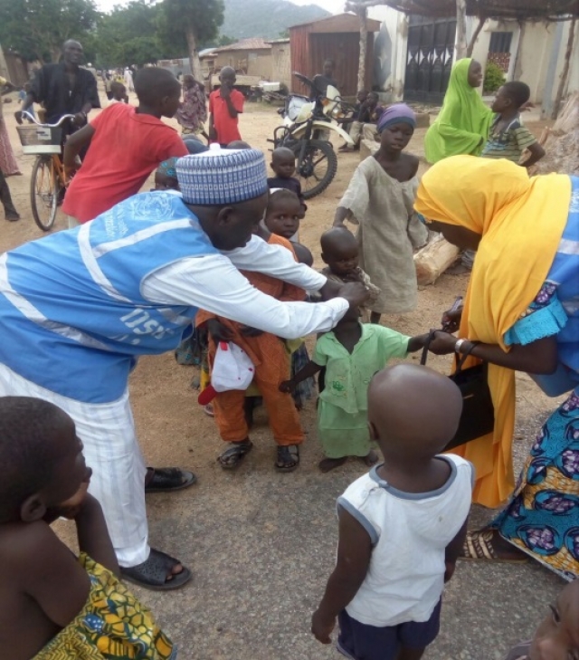 WHO personnel vaccinating a child in Gwoza