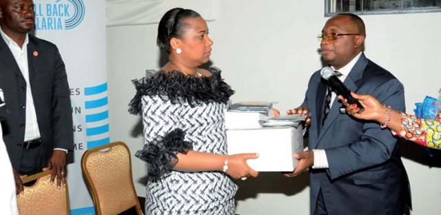 La Première Dame de la RDC, Mme Olive Lembe Kabila recevant symboliquement des médicaments antipaludéens de la part du Ministre de la Santé Publique lors du lancement officiel à Kinshasa de la campagne de sensibilisation sur l’Initiative: Faire reculer le Paludisme et l’élimination de la transmission du VIH de la Mère à l’Enfant