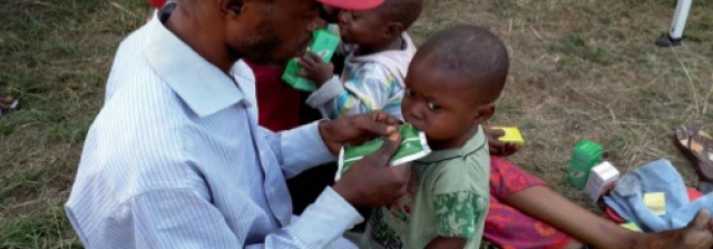 Un père de famille s’occupant à nourrir son enfant sur le site pour lui éviter la malnutrition qui guette un bon nombre d’enfants des expulsés.