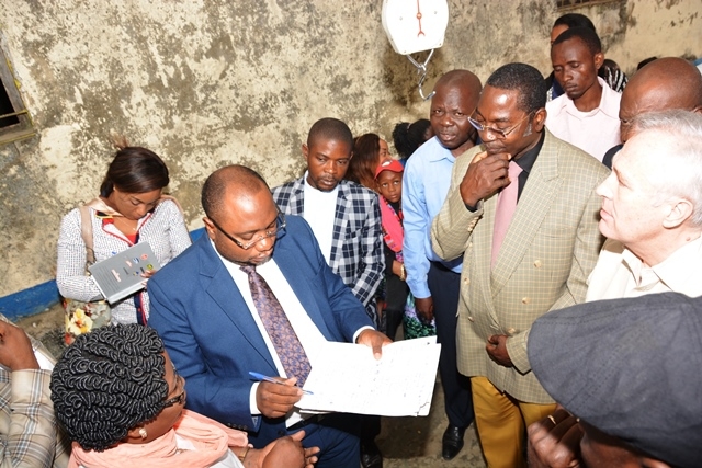 Le Dr Félix KABANGE NUMBI, MSP vérifiant les listes des personnes vaccinées au 2ème jour et la gestion des vaccins en présence des représentants de l'OMS et de l'UNICEF à Kisenso
