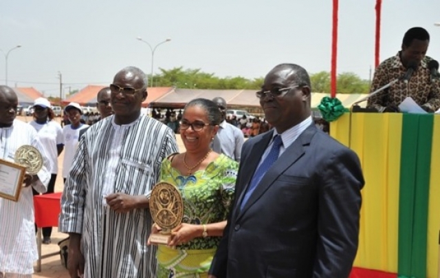 Madame le Représentant (au centre), reçoit un trophée pour la qualité de l’action et le partenariat actif de l’OMS . A sa droite, le Ministre de l’action sociale et de la solidarité nationale, Dr. Alain Zoubga et à sa gauche, le Ministre de la santé.