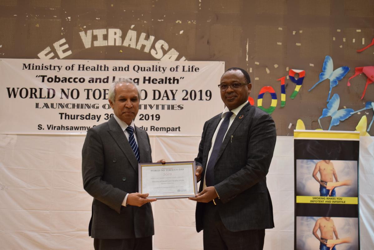  Dr Hon Anwar Husnoo, Minister of Health and Quality of Life receiving the ‘Certificate of Appreciation’ from Dr Laurent Musango, WHO Representative in Mauritius on behalf of Dr Tedros, Director General and Dr Moeti, Regional Director of the World Health Organization during the celebration of the World No-Tobacco Day 2019