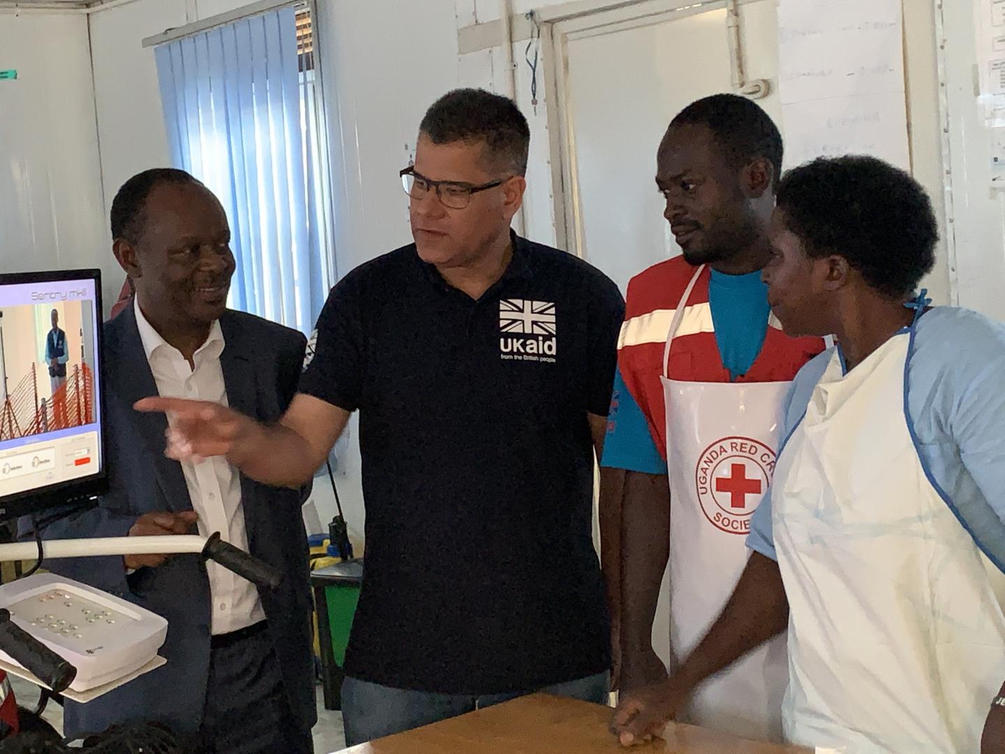 The Acting Director General of Health Services Dr Henry Mwebesa, Hon Alok Shama getting an explanation about the temperature scanners from health workers. 