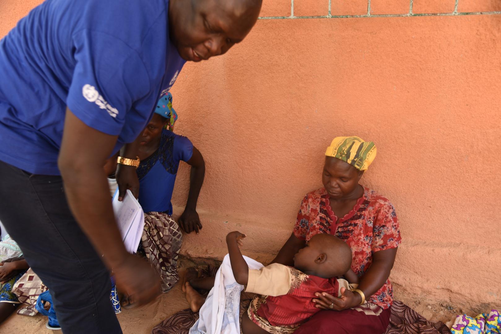 L’incident Manager, le Dr ITAMA  MAYIKULI Christian s’imprègne ici de l’état de santé  d’un enfant avec sa mère déplacée à Pissila.