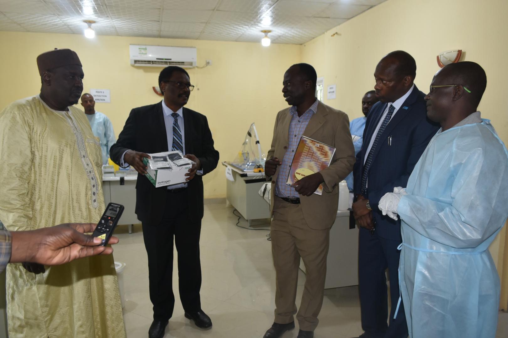 Les kits de réactifs COVID-19 remis officiellement par l’OMS aux autorités sanitaires nationales. A gauche et au premier plan (costume sombre) le Ministre de la santé publique